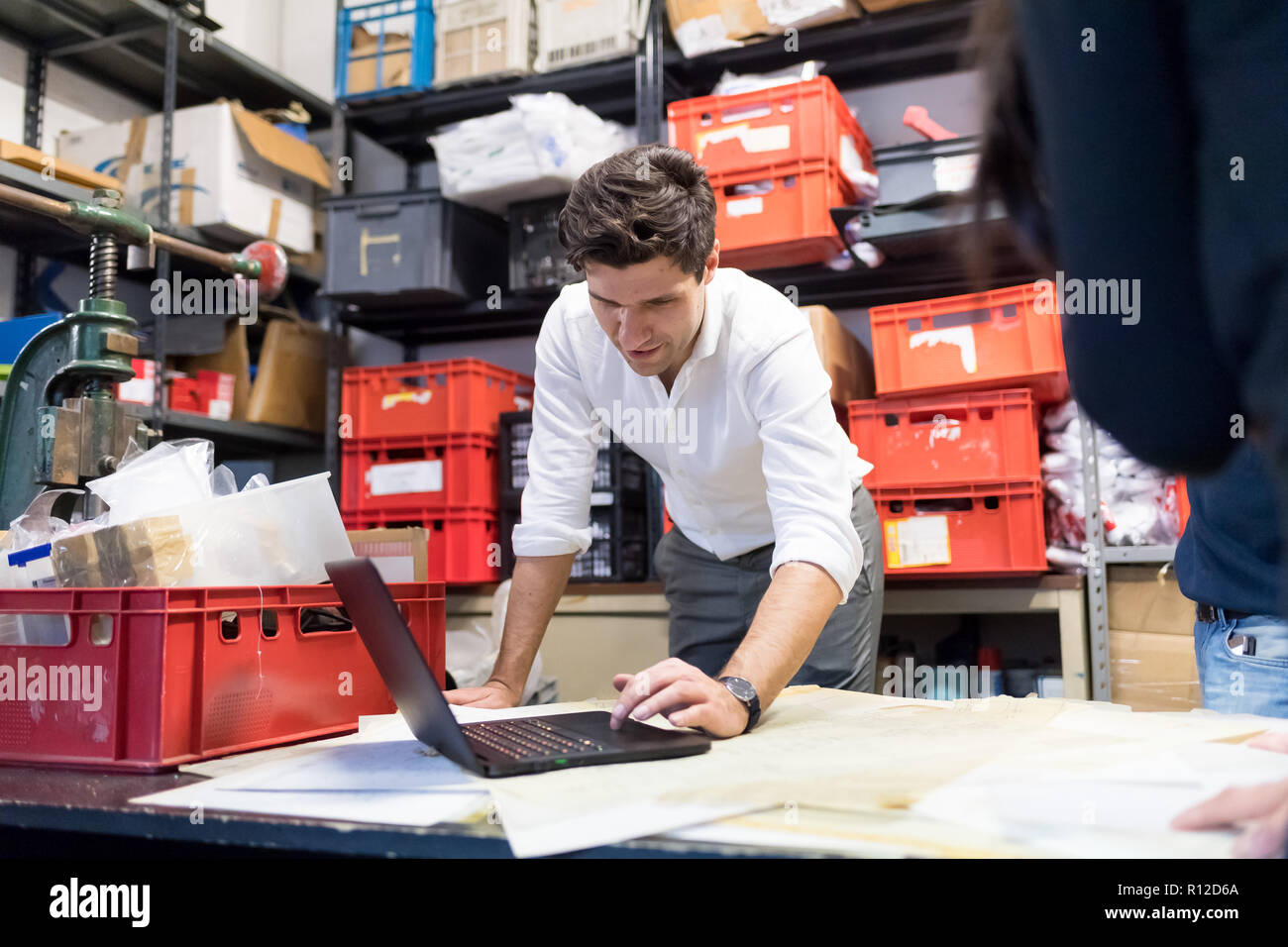 Man using laptop in demonstration in warehouse Stock Photo