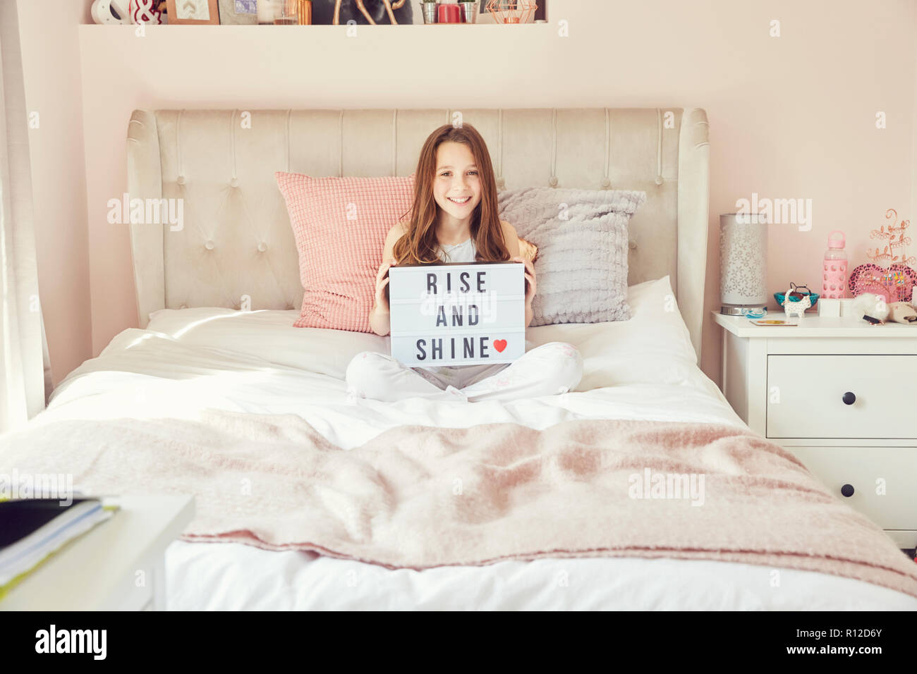 Girl holding up sign in bed Stock Photo Alamy