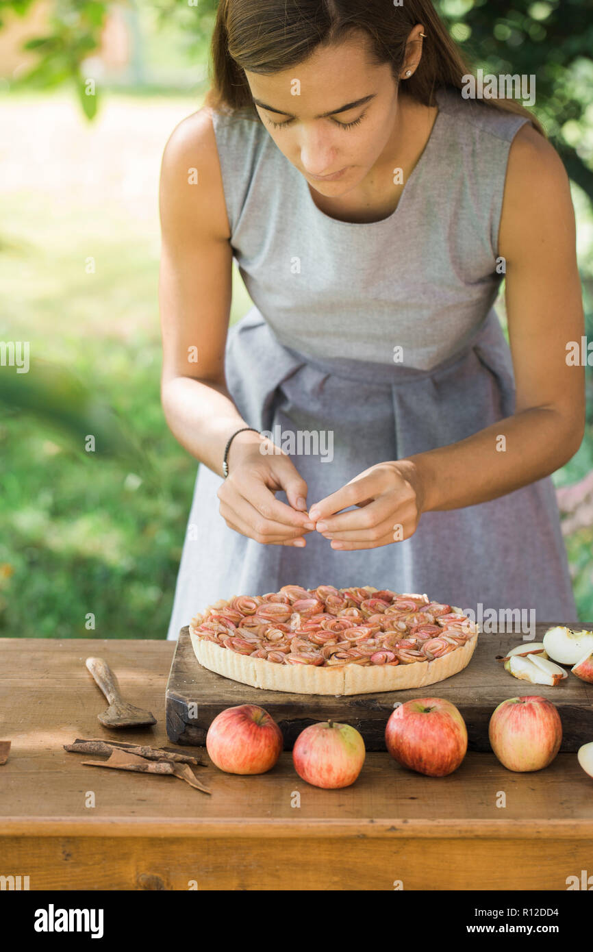 Woman preparing apple pie on table Stock Photo