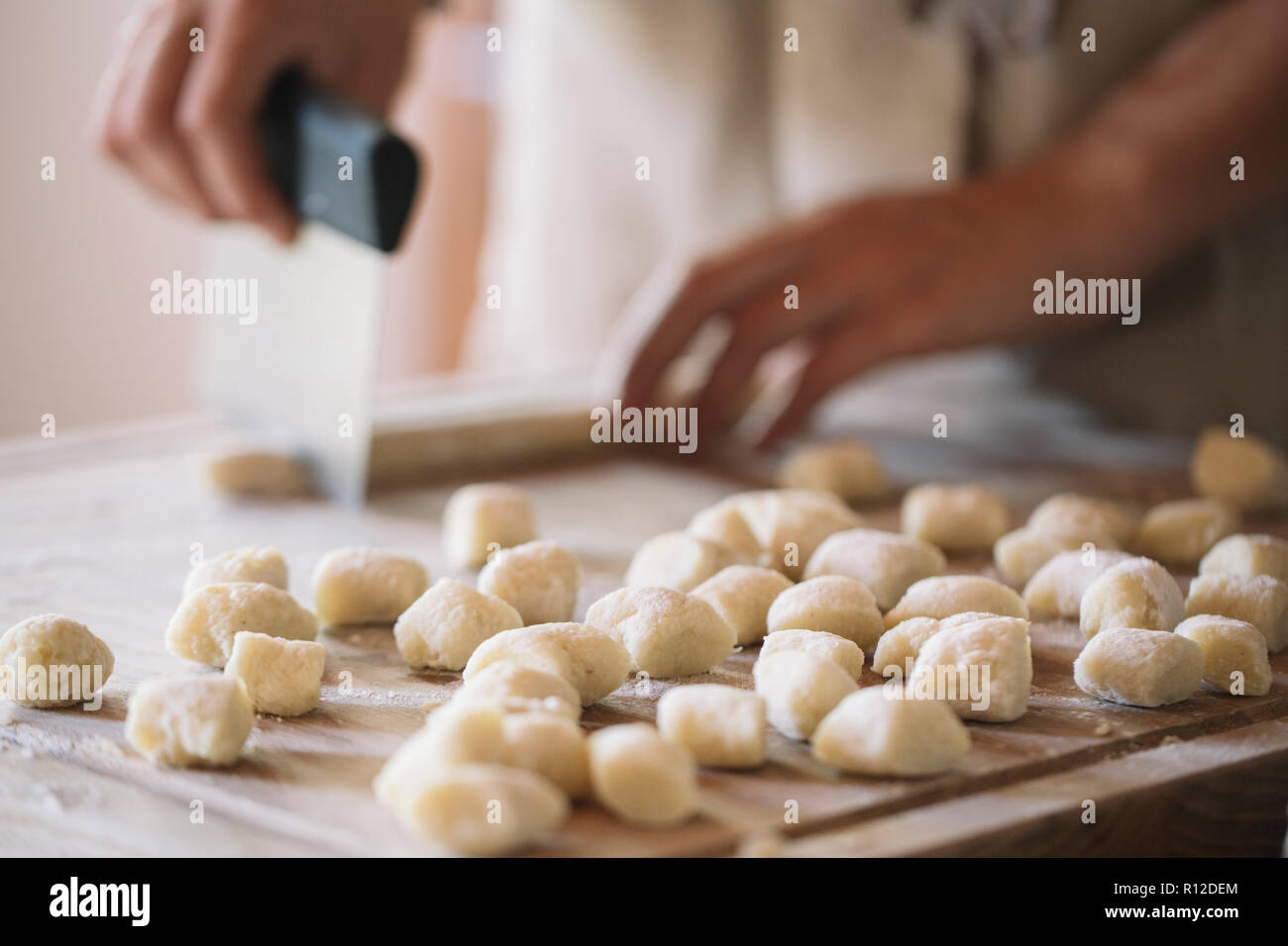 Woman cutting dough for gnocchi Stock Photo