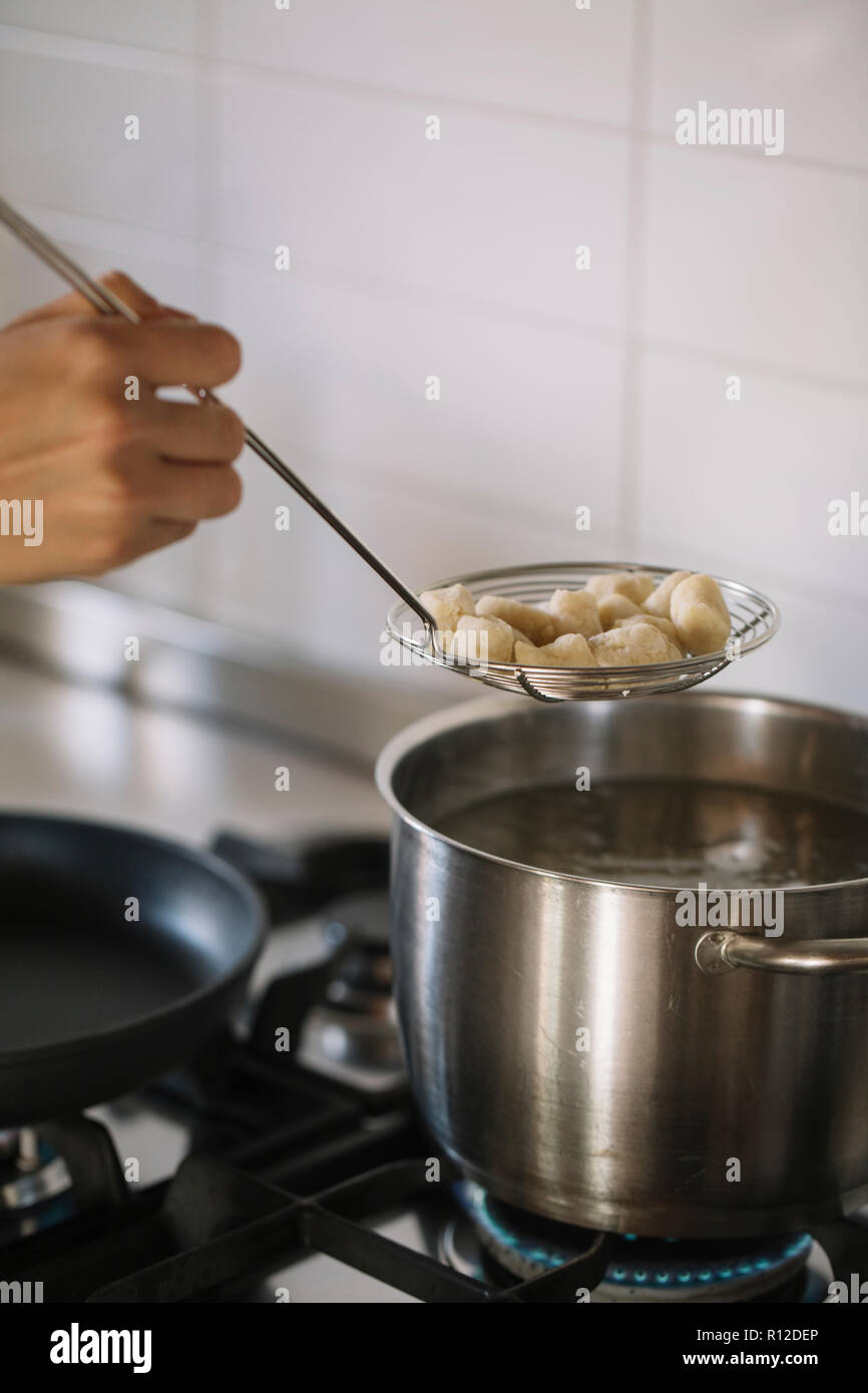 Potato gnocchi being removed from pot Stock Photo