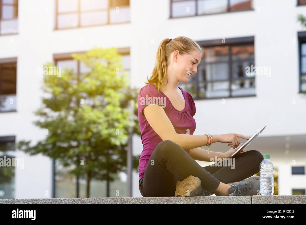 Young woman using digital tablet in park Stock Photo