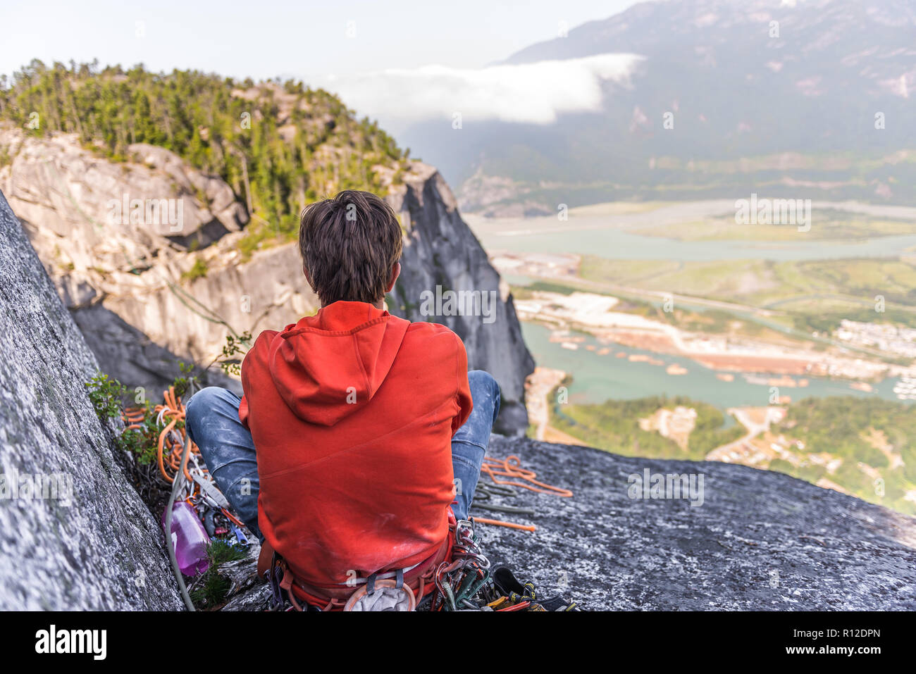 Rock climber relaxing at top of rock, Squamish, Canada Stock Photo