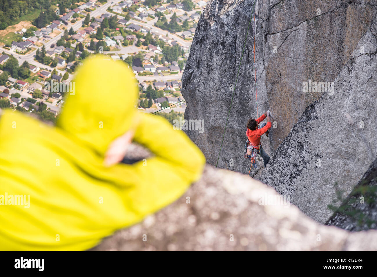 Rock climber waiting for team mate, Squamish, Canada Stock Photo