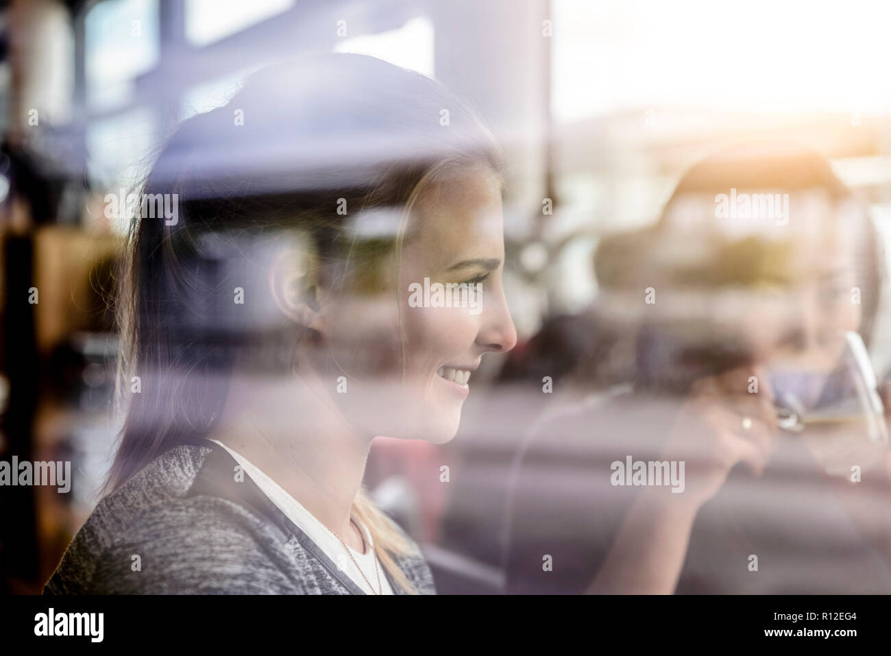 Two female students having coffee in cafe window seat Stock Photo