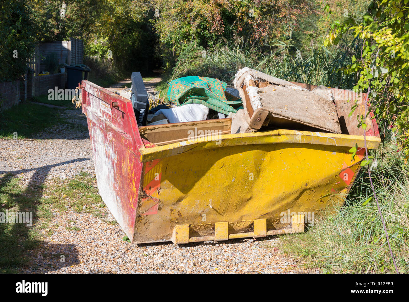 Metallic industrial building waste skip loaded up with rubble and