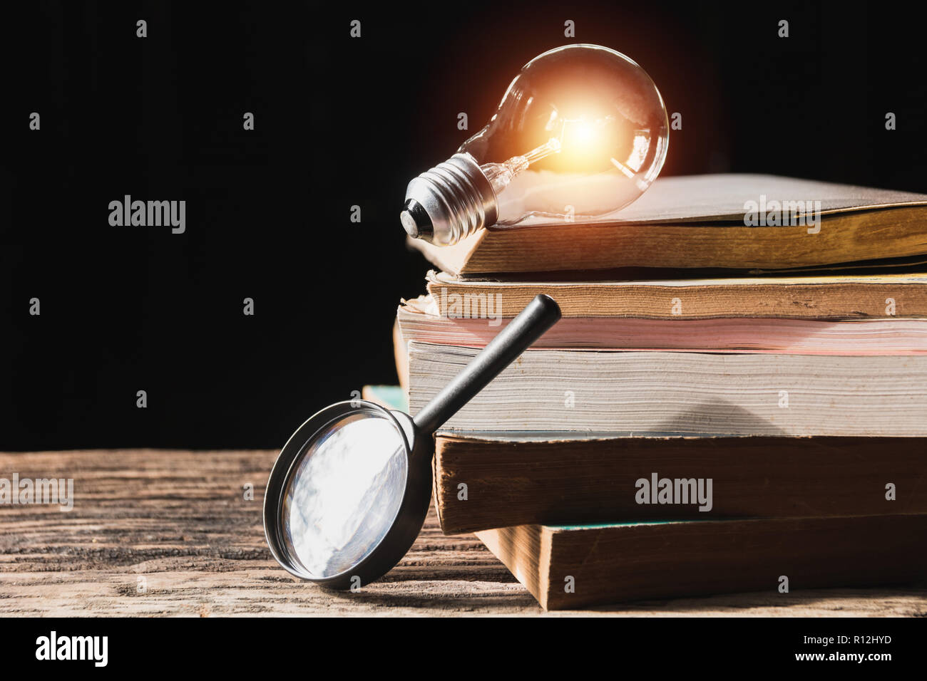 Light bulb and pile of book on wooden table and copy space for insert text. Stock Photo