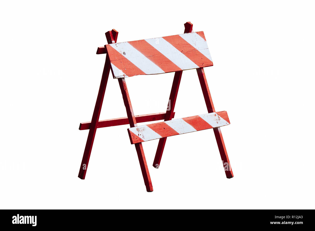 Red and white painted vintage wooden road block or barrier as wood frame barricade with four legs isolated on a seamless white background. Stock Photo