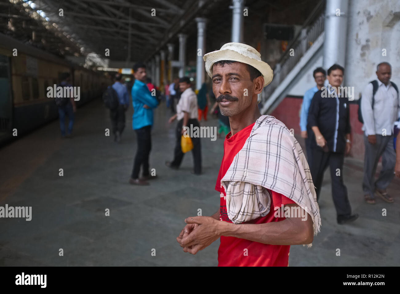 A porter at Chhatrapati Shivaji Maharaj Terminus (CSMT) in Mumbai, India, enjoying at bit of spare time before the next load of goods comes in Stock Photo