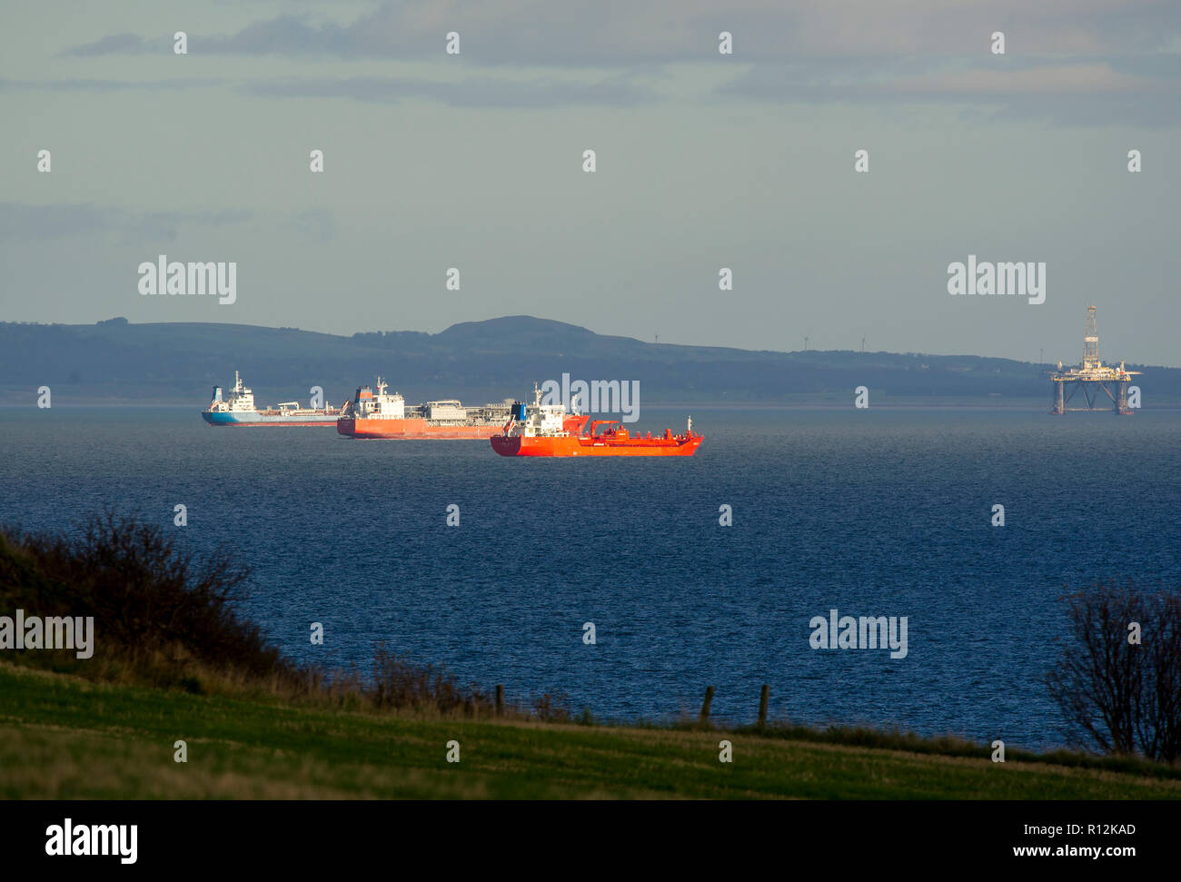 Commercial ships anchored off the east coast of Scotland in the Firth of Forth. Stock Photo