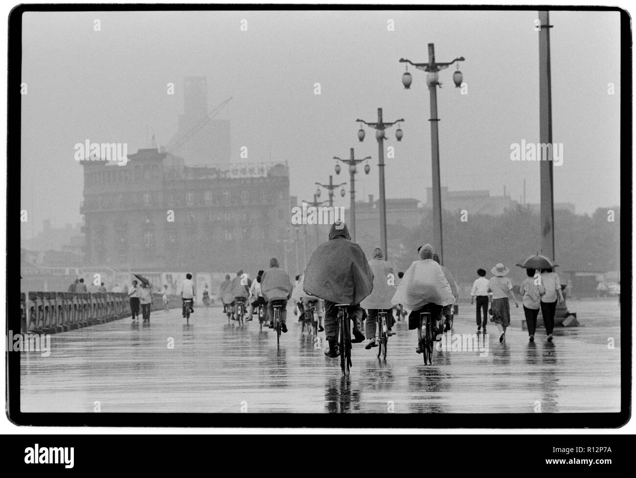 China Shanghai a few days after the massacre in Tiananmen Square in June 1989. Scans made in 2018 Men and wonen on bicycles in Shanghai in the rain. Stock Photo