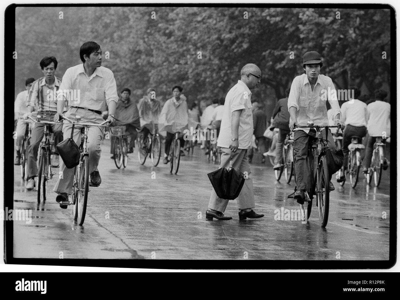 China Shanghai a few days after the massacre in Tiananmen Square in June 1989. Scans made in 2018 Men and wonen on bicycles in Shanghai in the rain. Stock Photo