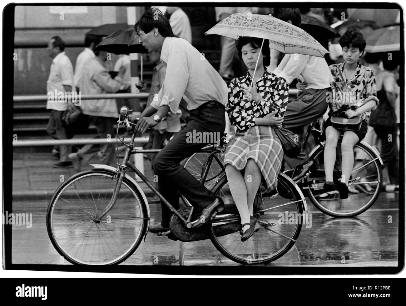 China Shanghai a few days after the massacre in Tiananmen Square in June 1989. Scans made in 2018 Men and wonen on bicycles in Shanghai in the rain. Stock Photo