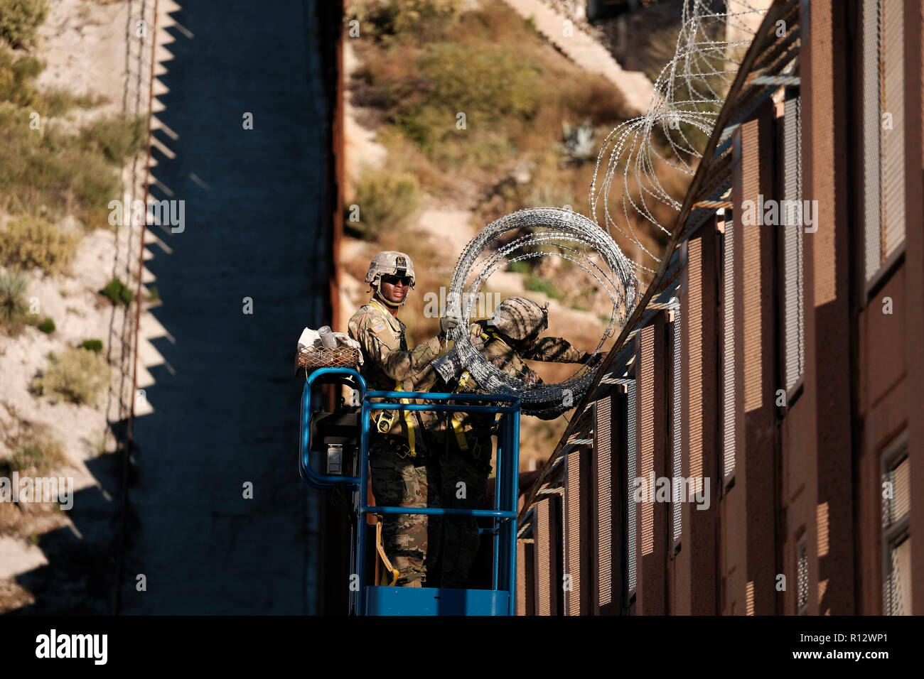 Nogales, Arizona, USA. 7th Nov, 2018. The US Army laying barbed wire on top of the border wall at international border station in Nogales, Arizona. The soldiers are part of the 5,000 troops that President Trump has ordered the Pentagon to dispatch to the Southwest border to assist the US Border Patrol in advance of the possible arrival of caravans of Central American migrants. Credit: Christopher Brown/ZUMA Wire/Alamy Live News Stock Photo