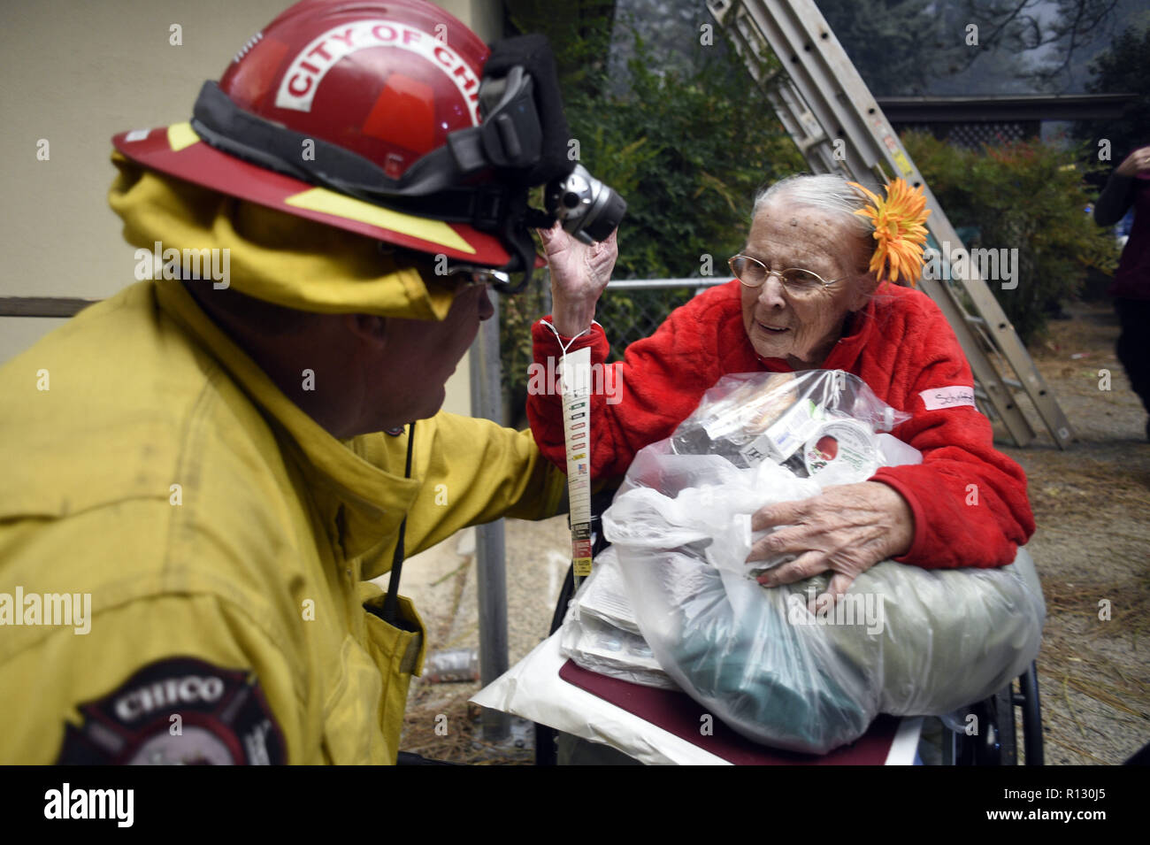 Paradise, California, USA. 8th Nov, 2018. Paradise, California, U.S. - Chico Fire and Rescue Capitan John Kelso jokes with Paradise Skilled Nursing home resident Katherine Schaffer as she waits to be evacuated. Credit: Neal Waters/ZUMA Wire/Alamy Live News Stock Photo