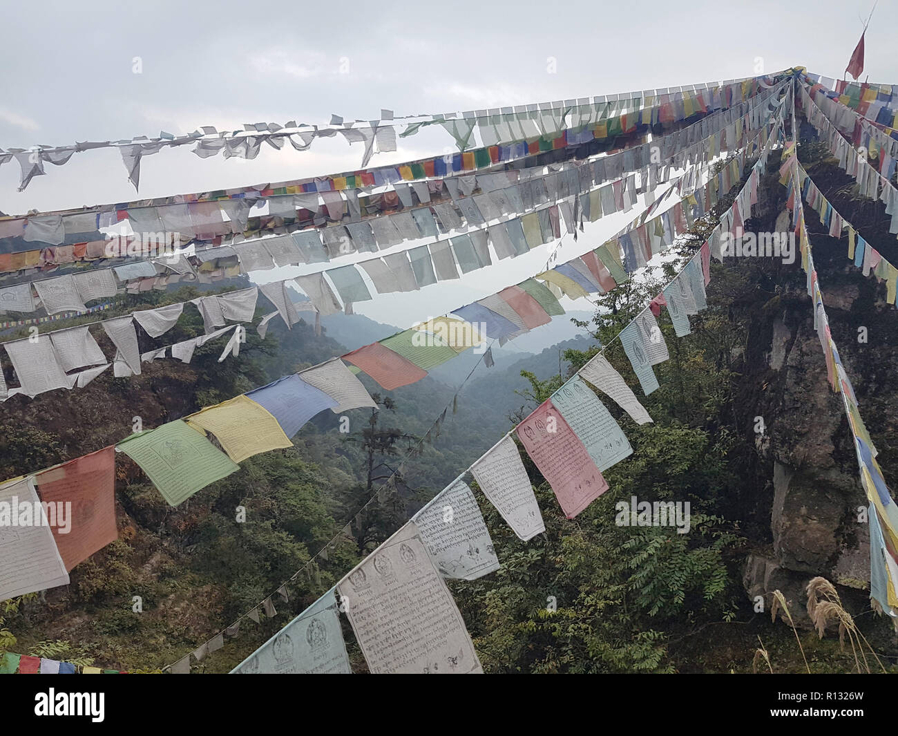 Wangdue Phodrang, Bhutan. 19th Oct, 2018. Buddhist prayer flags hanging between rocks in the central Bhutanese Phobjikha valley. In the small Himalayan kingdom, many people believe that Yetis live in Bhutan's mountains. Credit: Nick Kaiser/dpa/Alamy Live News Stock Photo