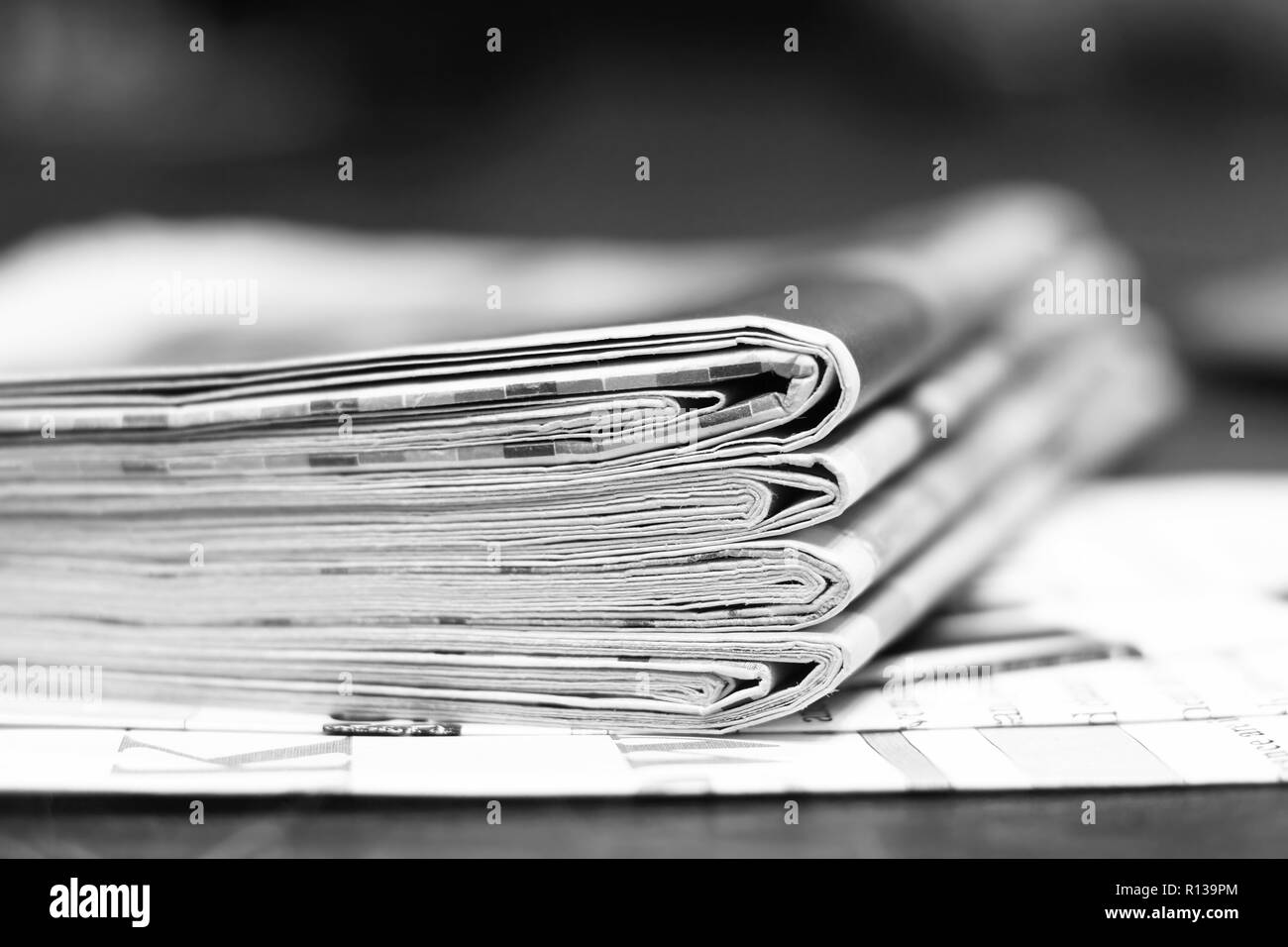 Pile of fresh morning newspapers on table at office. Latest financial and business news in daily paper. Pages with information (headlines, articles) Stock Photo