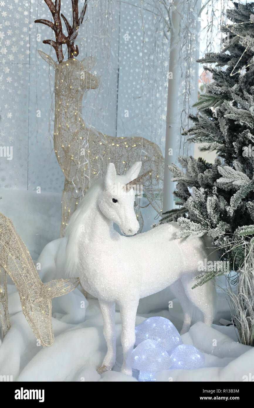 Christmas display in UK garden centre featuring a white unicorn Stock