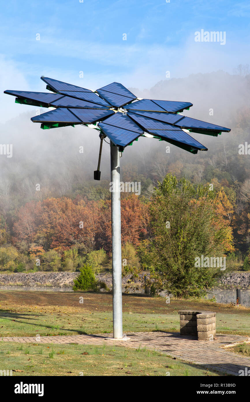 Solar array identified as  'Solar Photovoltaic Flair',  facilitates electric vehicle charging station, dissipating morning fog. Stock Photo