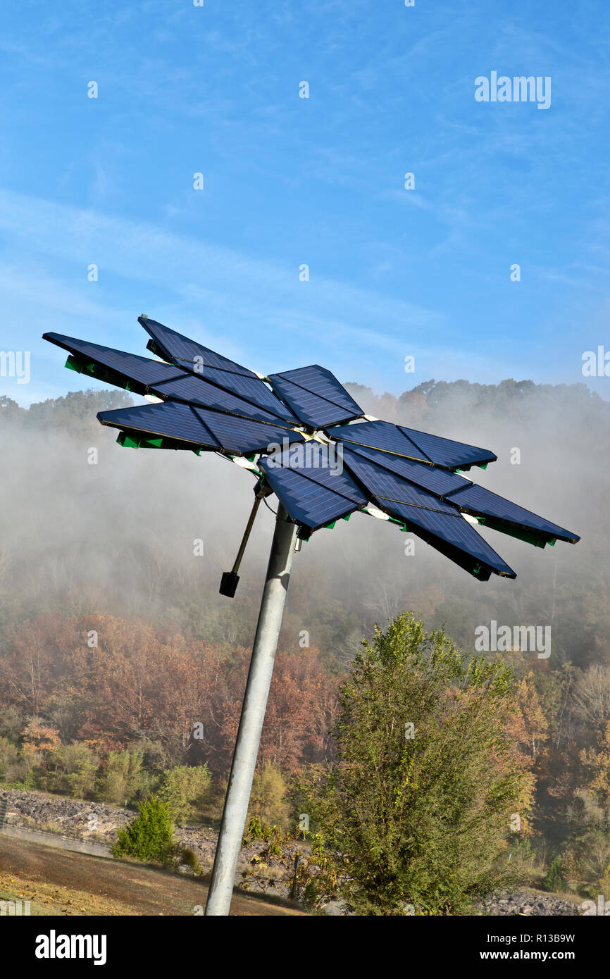 Solar array identified as a  'Solar Photovoltaic Flair',  facilitates electric vehicle charging station, dissipating morning fog. Stock Photo