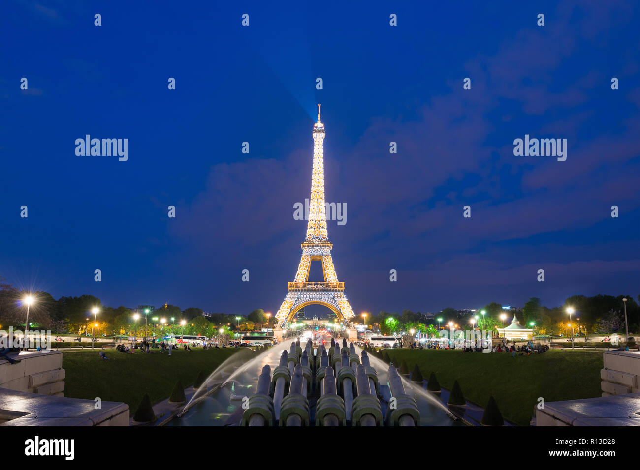 PARIS, FRANCE - May 8, 2016:  Tourist sightseeing beautiful night scene of illuminated Eiffel Tower at dusk, Paris, France. Stock Photo