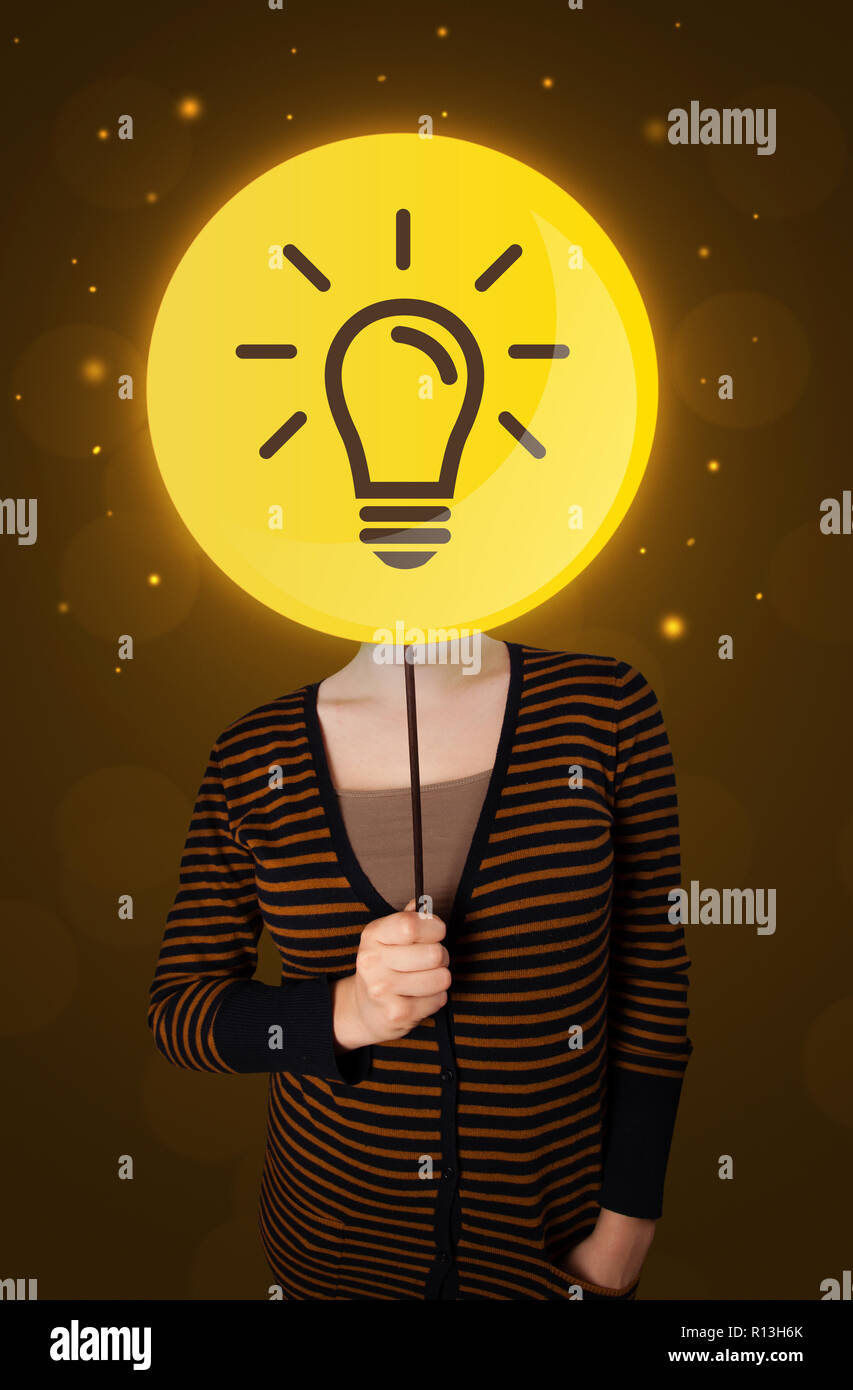 Casual young woman holding round sign with yellow lightbulb Stock Photo