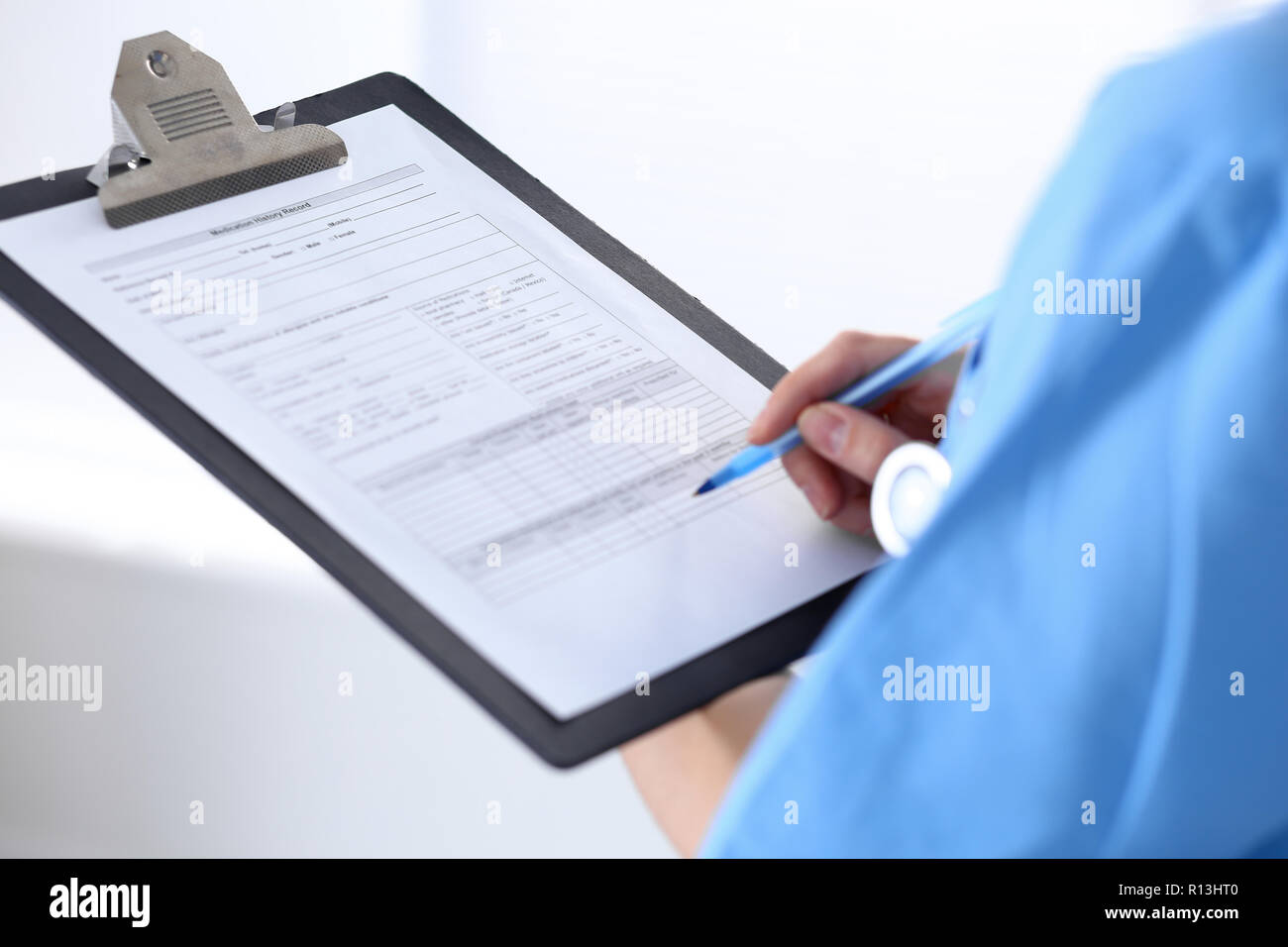 Female doctor filling up medical form on a clipboard, closeup ...