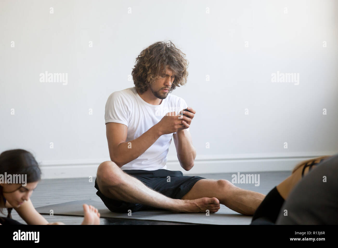 Young man sitting texting a message using his mobile phone Stock Photo