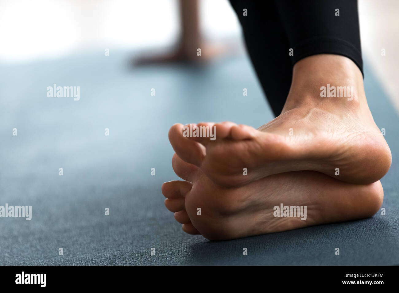 Women's bare feet connection on yoga cushions - Stock Image - F017