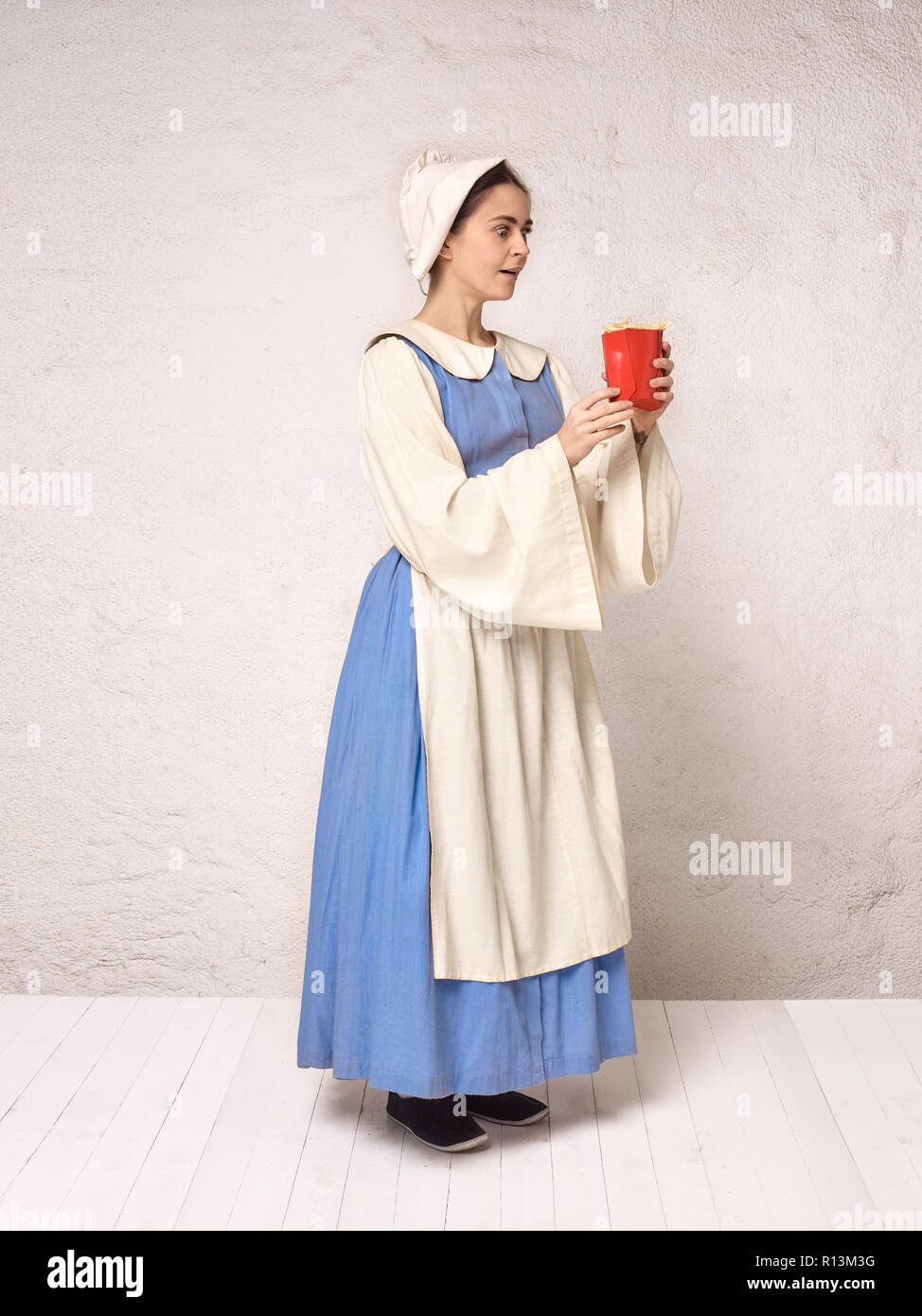 Medieval Woman in Historical Costume Wearing Corset Dress and Bonnet.  Beautiful peasant girl wearing thrush costume with French fries Stock Photo  - Alamy