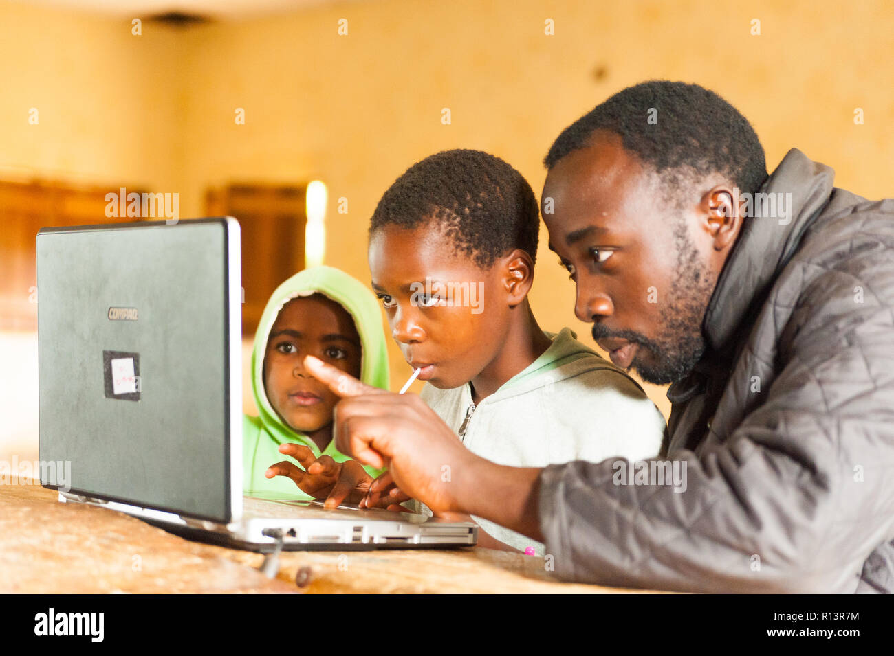 Bafoussam, Cameroon - 06 august 2018: young african teacher involve school children in learning technology with computer Stock Photo