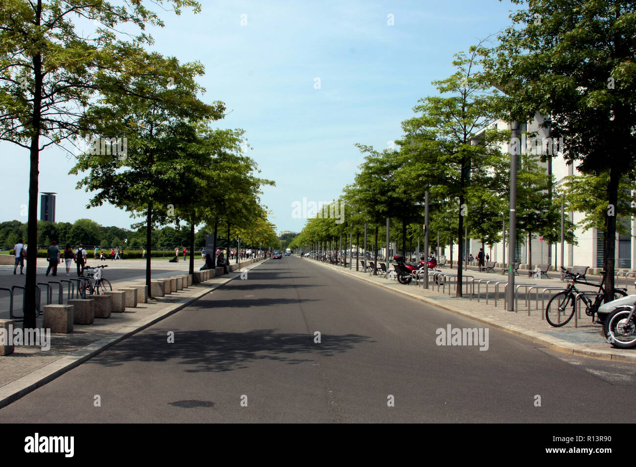 A long, straight and immaculate, tree lined thoroughfare or boulevard in Berlin, Germany. Stock Photo