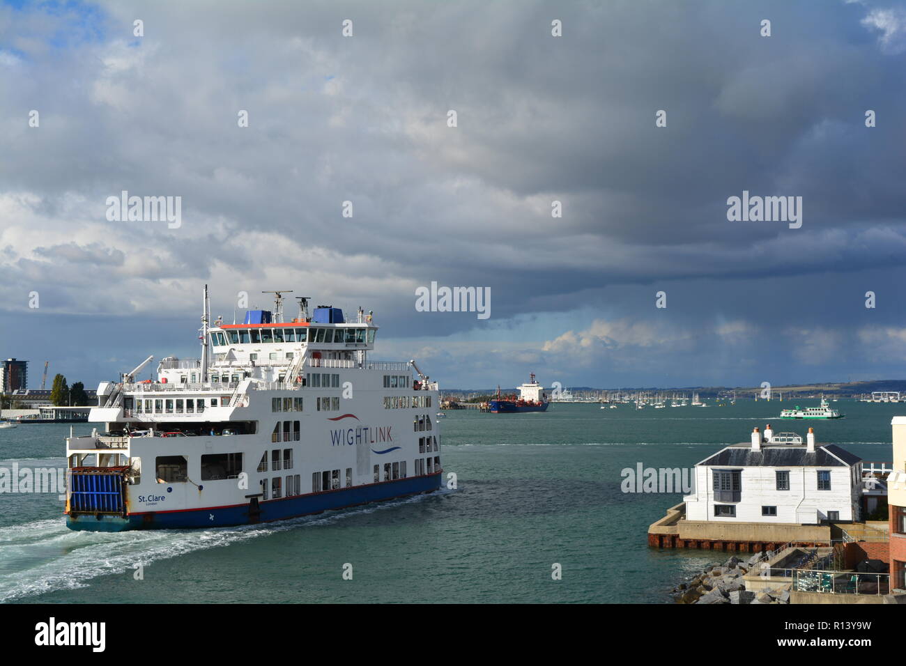 isle of wight ferry entering Portsmouth harbour with rainclouds in the distance Stock Photo