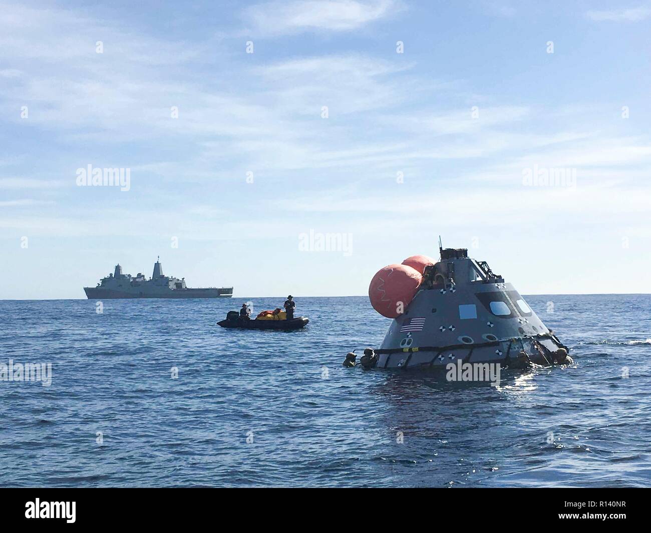 Sailors assigned to the amphibious transport dock ship USS John P. Murtha and NASA personnel retrieve a mock up version of the Orion space capsule during a recovery test November 7, 2018 in the Pacific Ocean. NASA and the U.S. Navy has not performed open ocean recovery of a manned space capsule since the Apollo project in the 60's and are testing procedures and hardware that will be used to recover the Orion spacecraft after it splashes down in the Pacific Ocean following future deep space exploration missions. Stock Photo