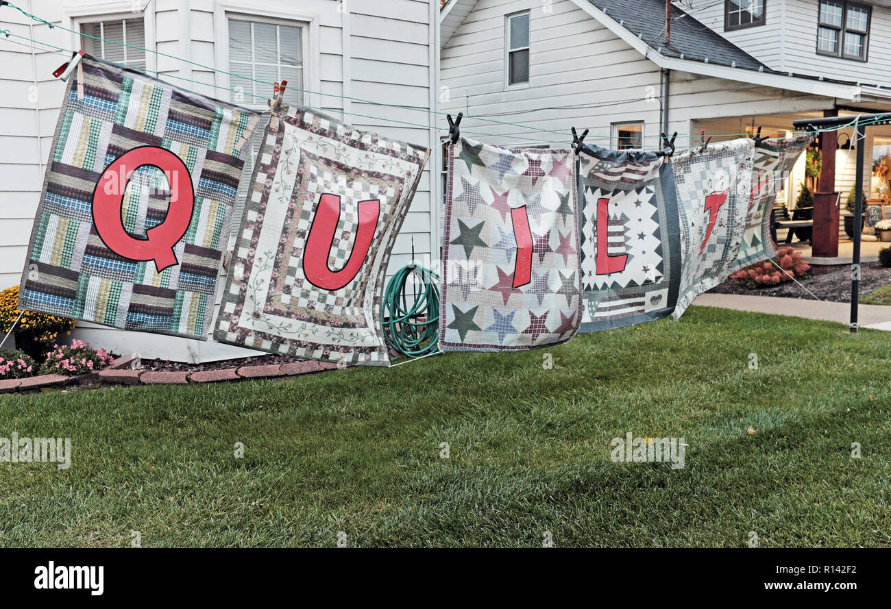 Six quilts hang outside a quilt business on the Amish Country Byway in the Amish community of Berlin, Ohio, USA. Stock Photo