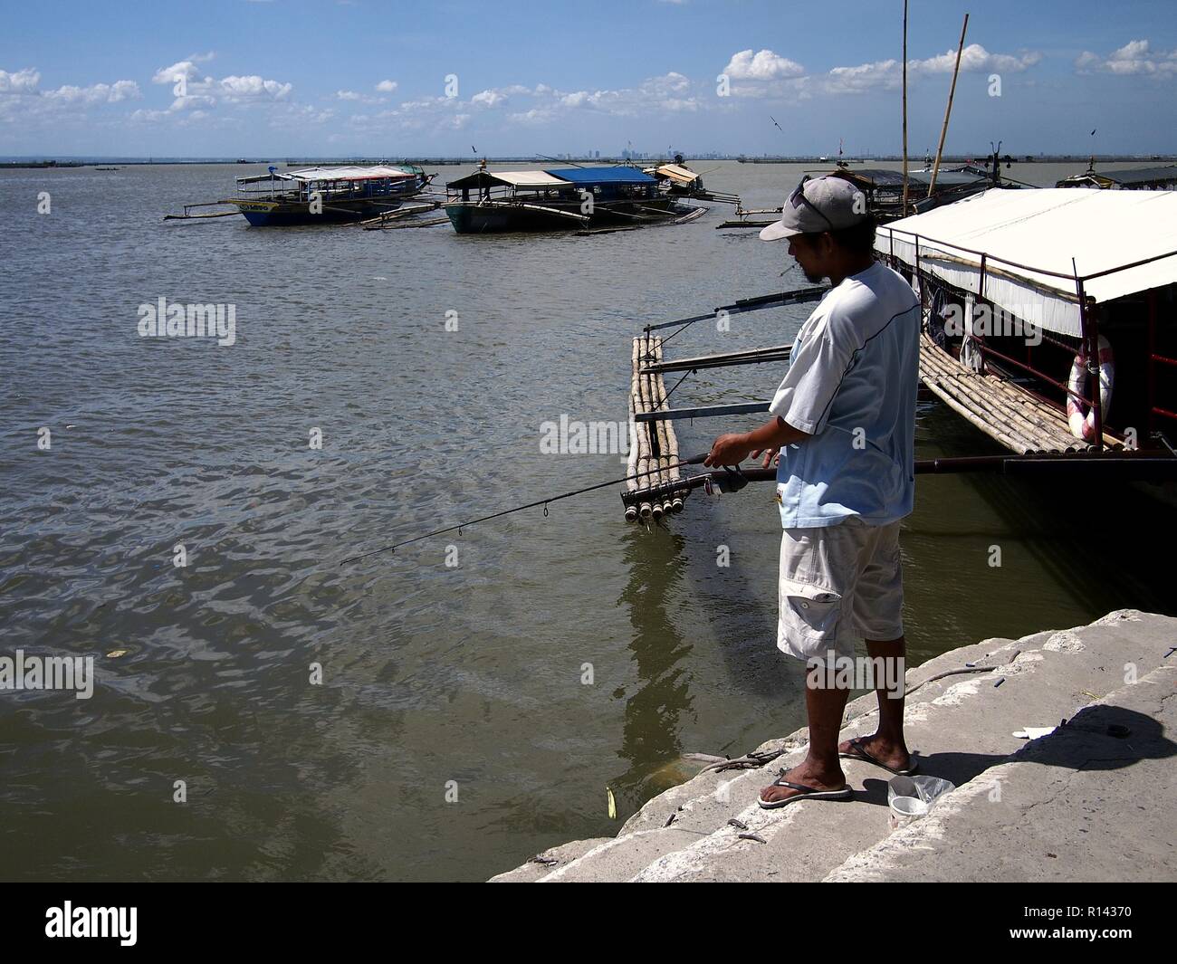 BINANGONAN, RIZAL, PHILIPPINES NOVEMBER 8, 2018 Men tries to catch fish using a fishing pole