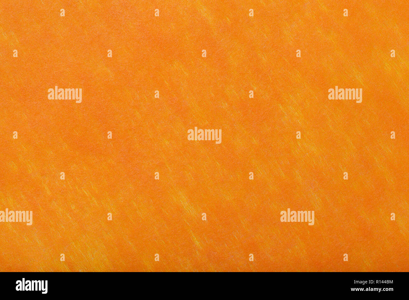 Construction of a bright orange background with light yellow spots of felt fabric, closeup