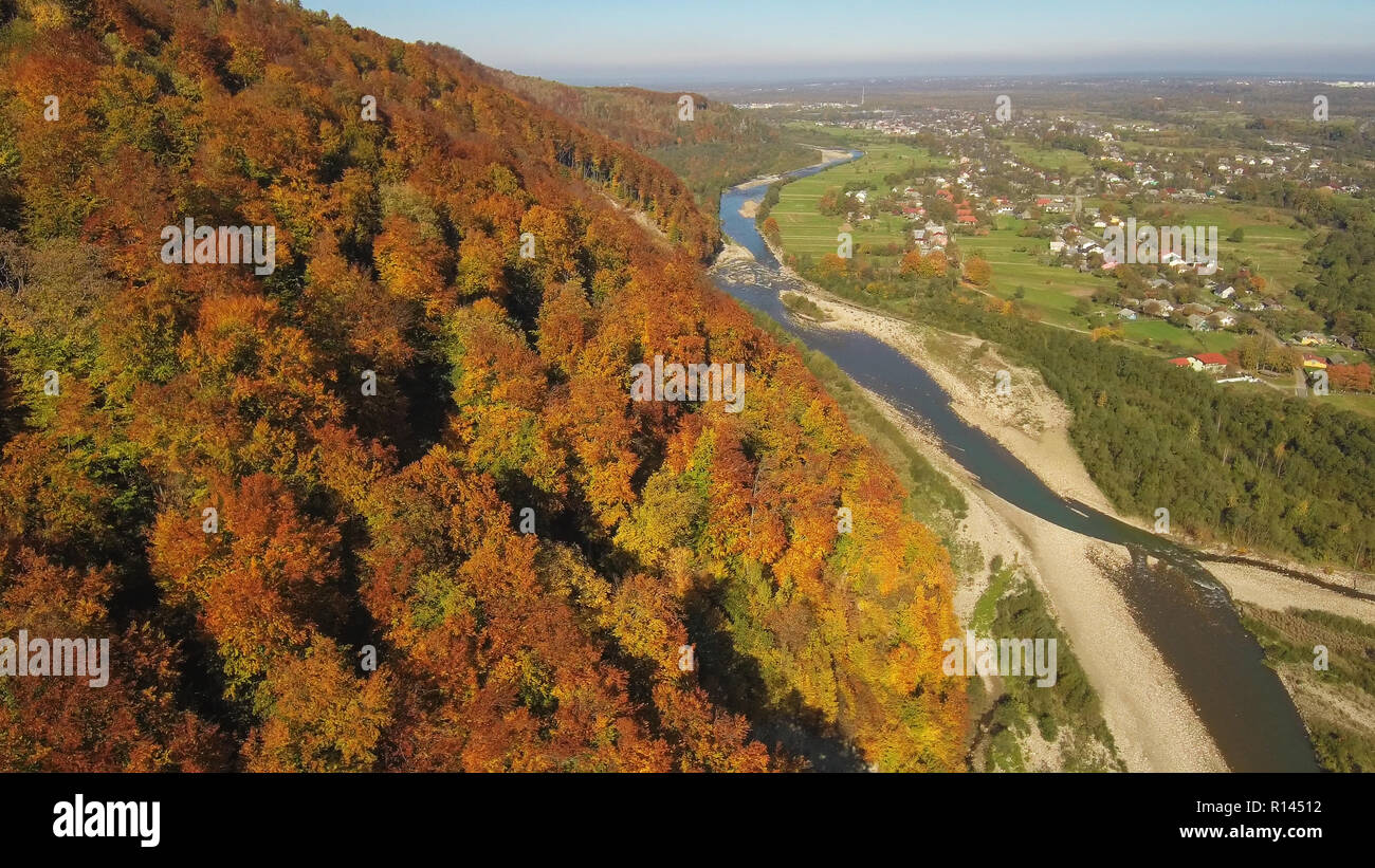 Aerial, top view from Drone: flying over the mountain with forest and river. Stock Photo