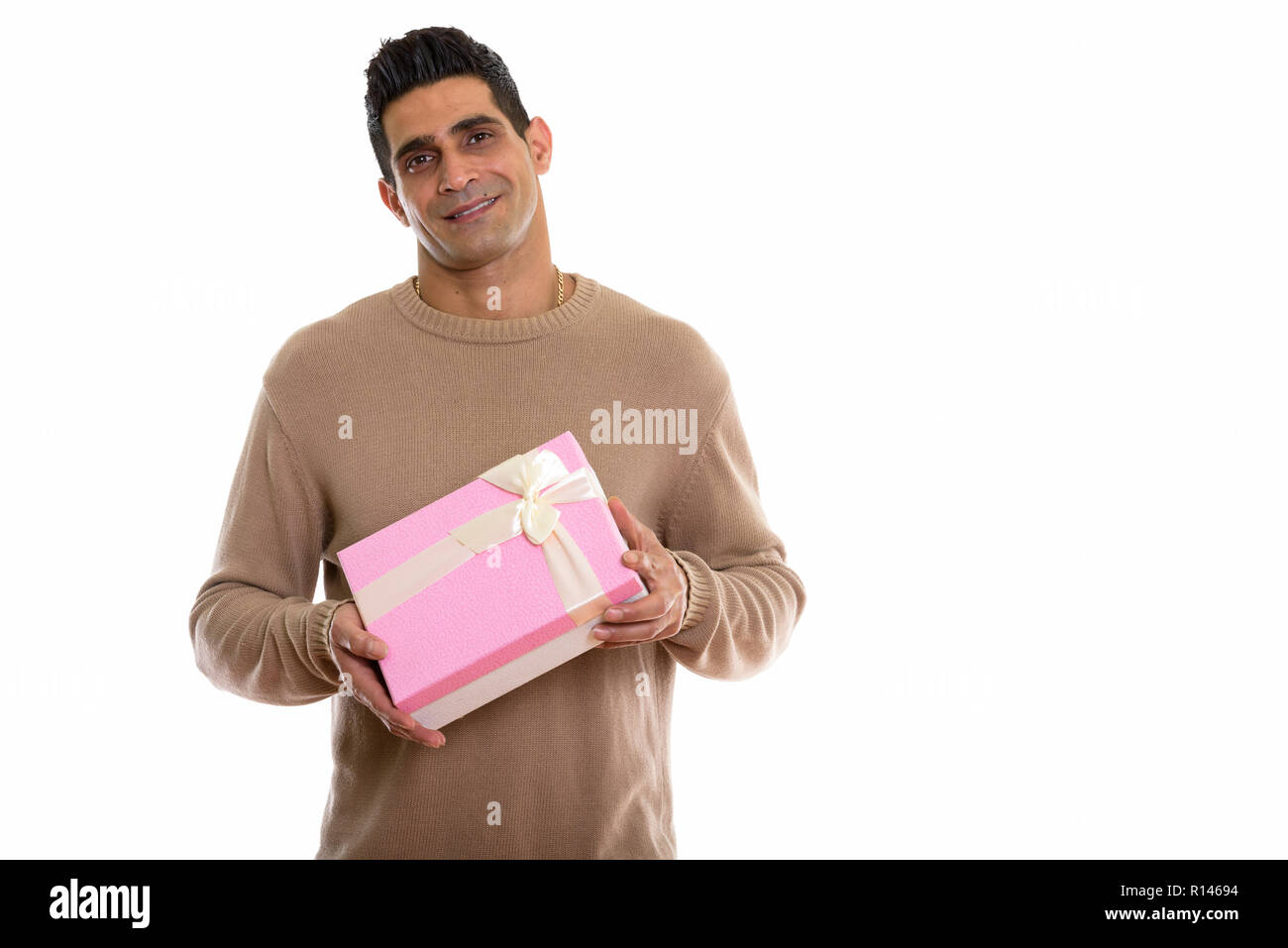 Studio shot of young happy Persian man smiling while holding gif Stock ...