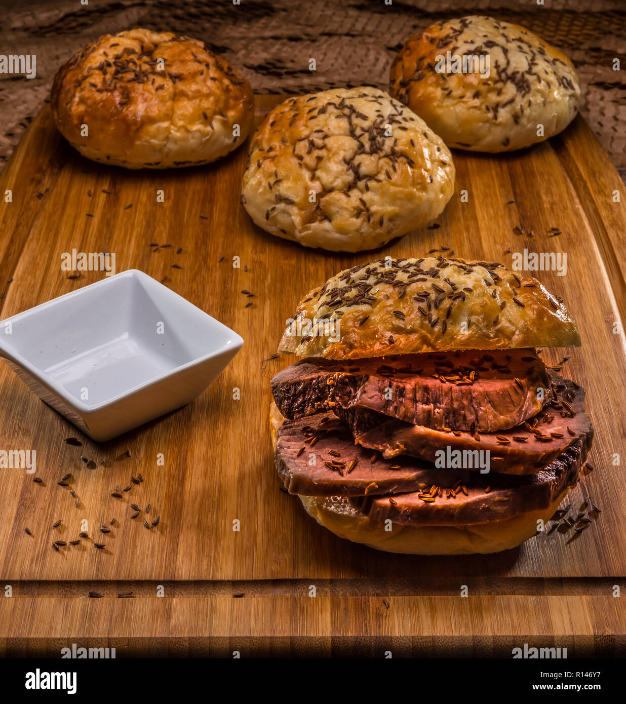roastbeef on kimmelweck roll on wooden cutting board with au jus Stock
