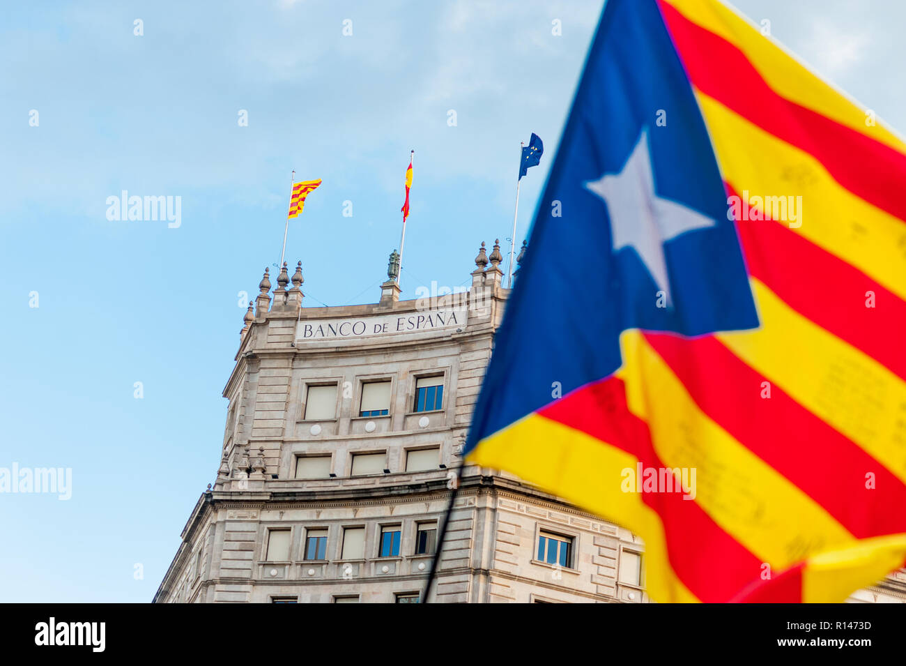catalan flag waving in front of bank of spain building in barcelona city center during indepence march symbol of economic issue Stock Photo