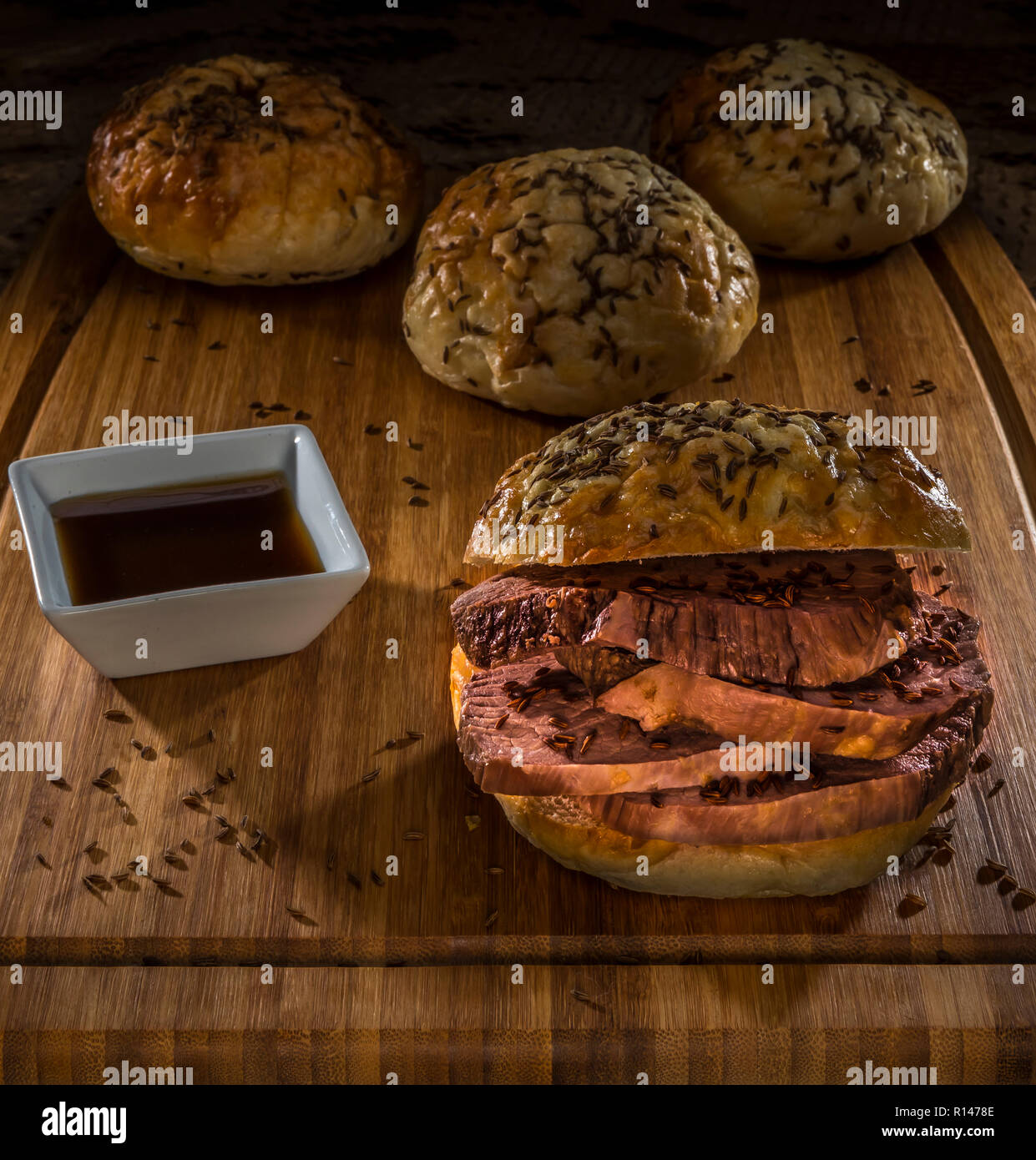 roastbeef on kimmelweck roll on wooden cutting board with au jus Stock