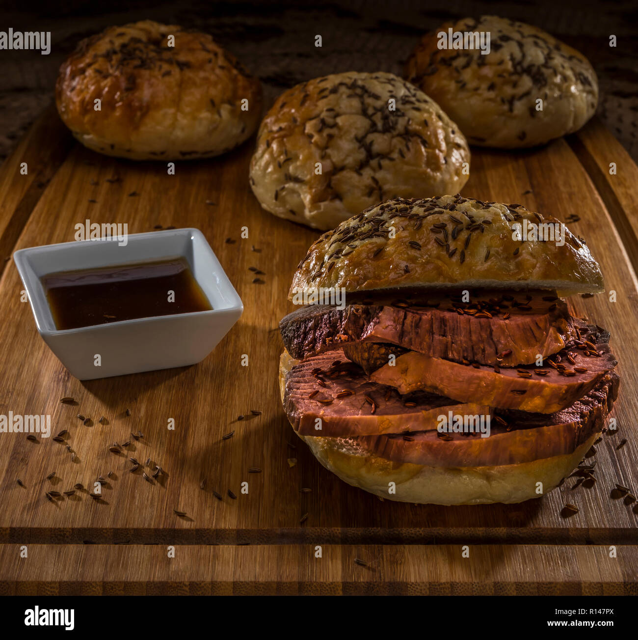 roastbeef on kimmelweck roll on wooden cutting board with au jus Stock