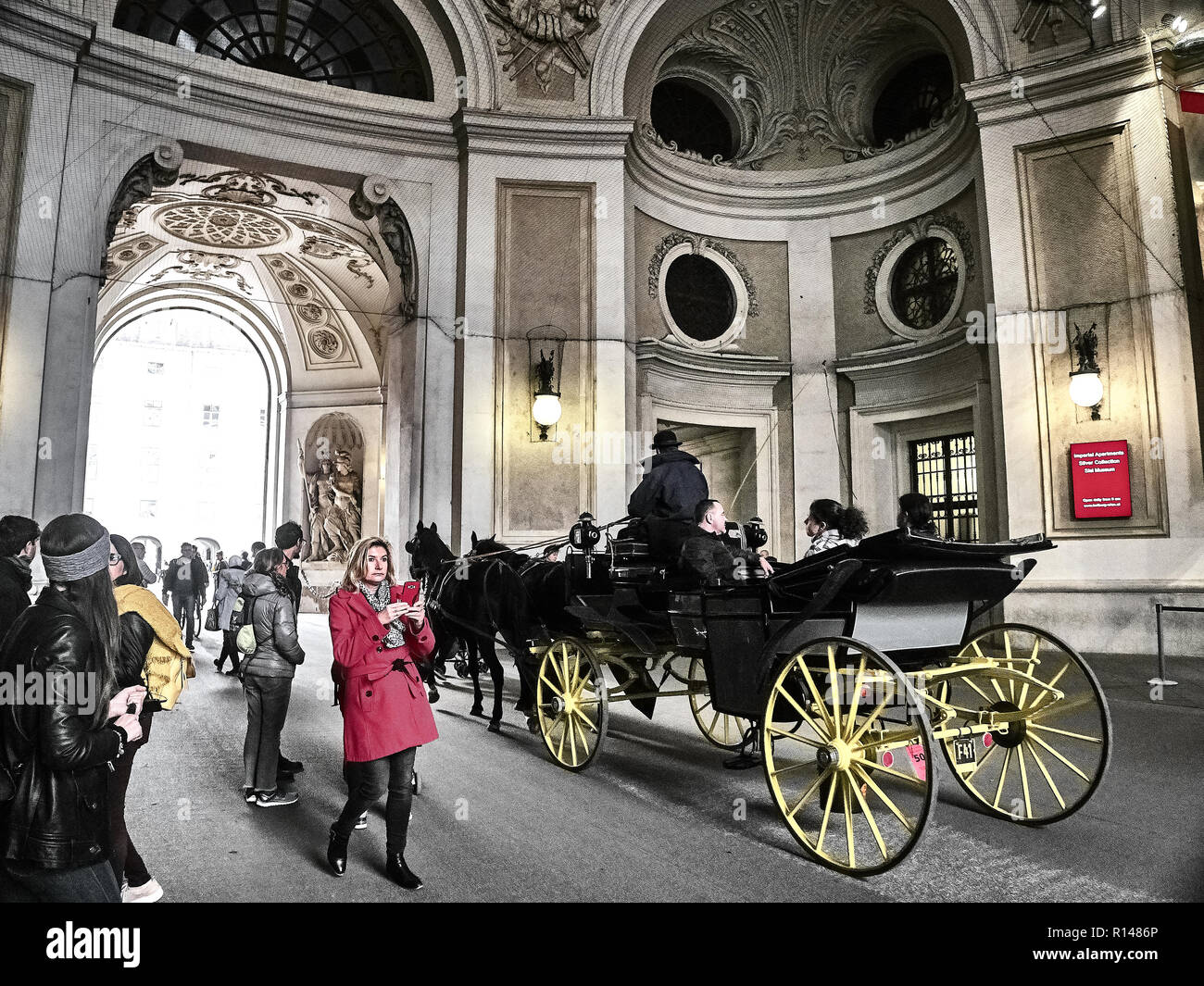 Vienna, Austria - November 1, 2018 - A horse-drawn carriage passing inside the Hofburg palace. People are visiting the palace Stock Photo
