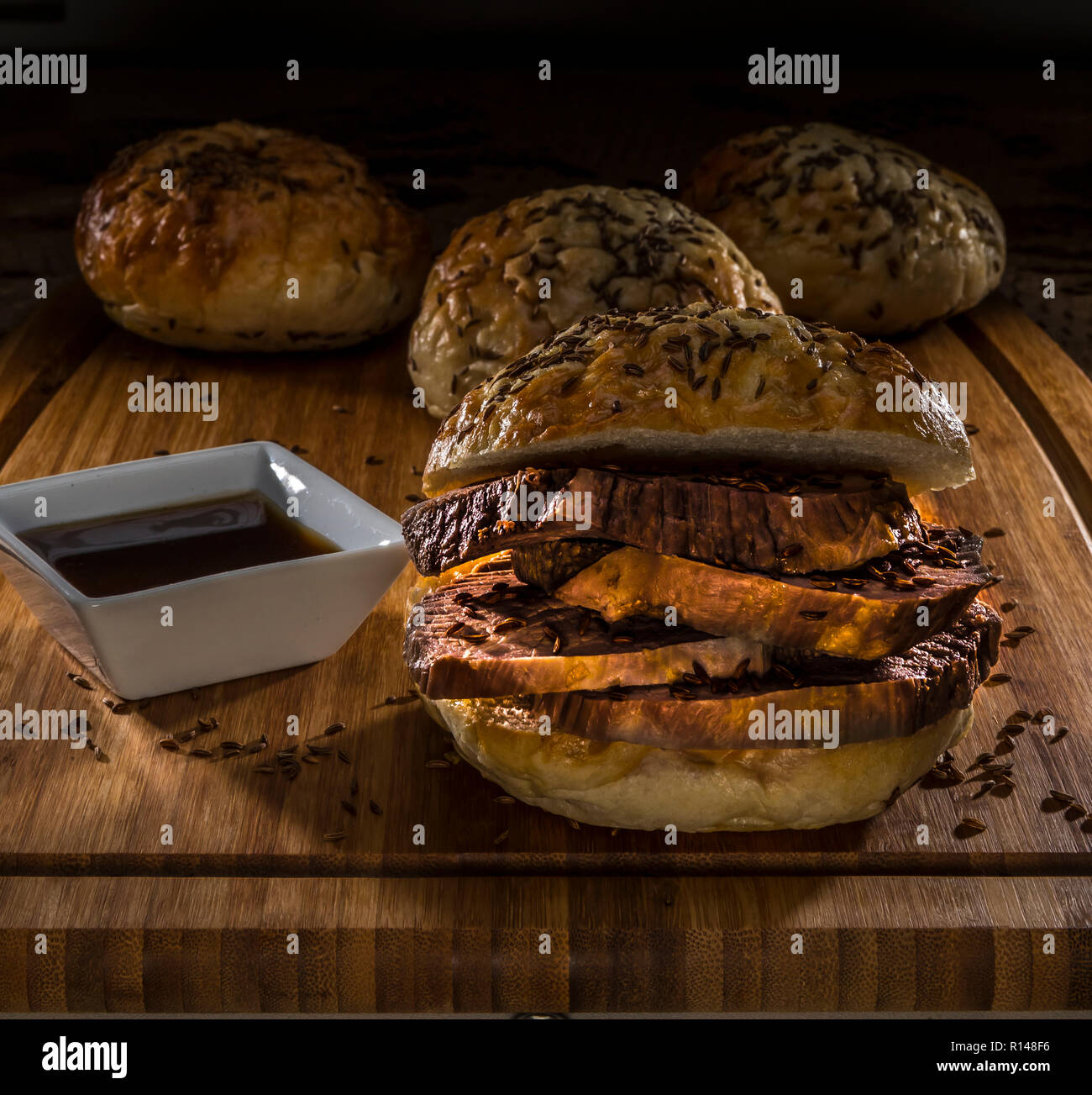 roastbeef on kimmelweck roll on wooden cutting board with au jus Stock