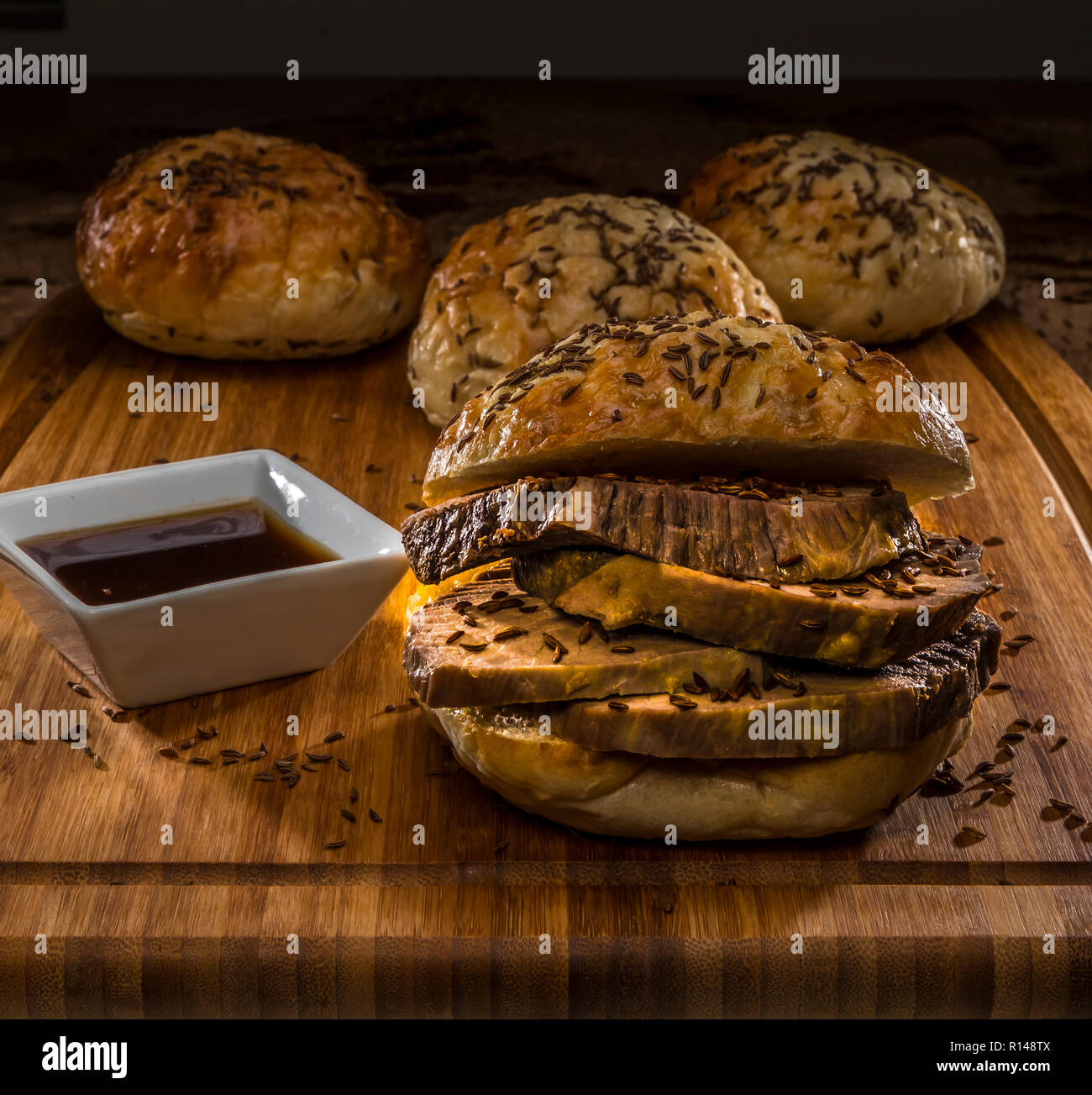 roastbeef on kimmelweck roll on wooden cutting board with au jus Stock