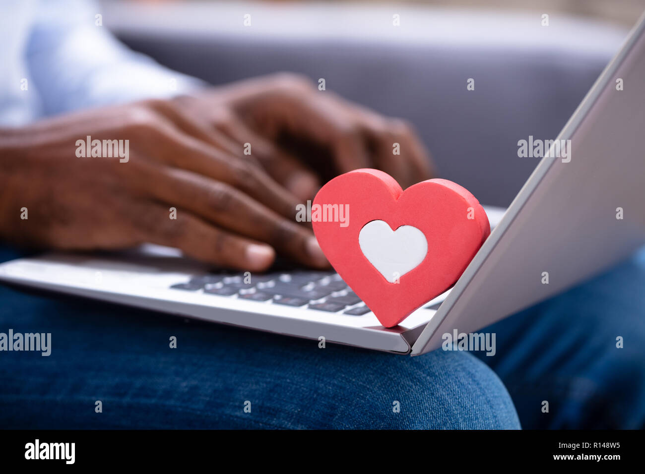 Close-up Of Red Heartshape On Keypad While Man's Hand Using Laptop Stock Photo