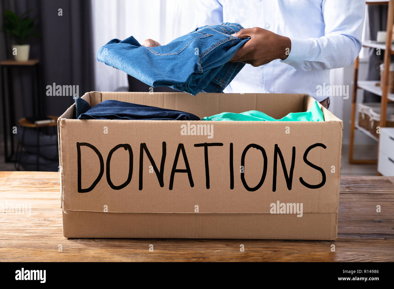 African Man Putting Clothes In Donation Box Stock Photo Alamy