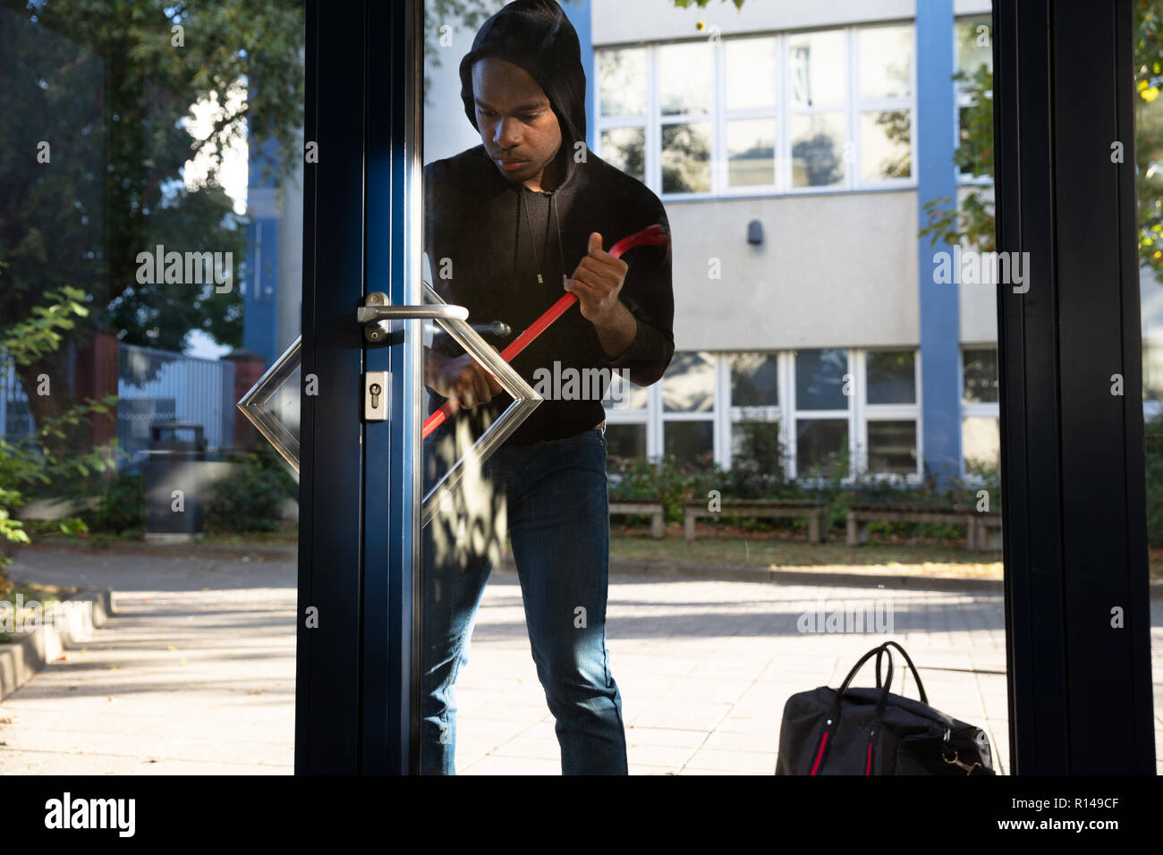 Thief Entering Home By Breaking Glass Door With Crowbar Stock Photo Alamy