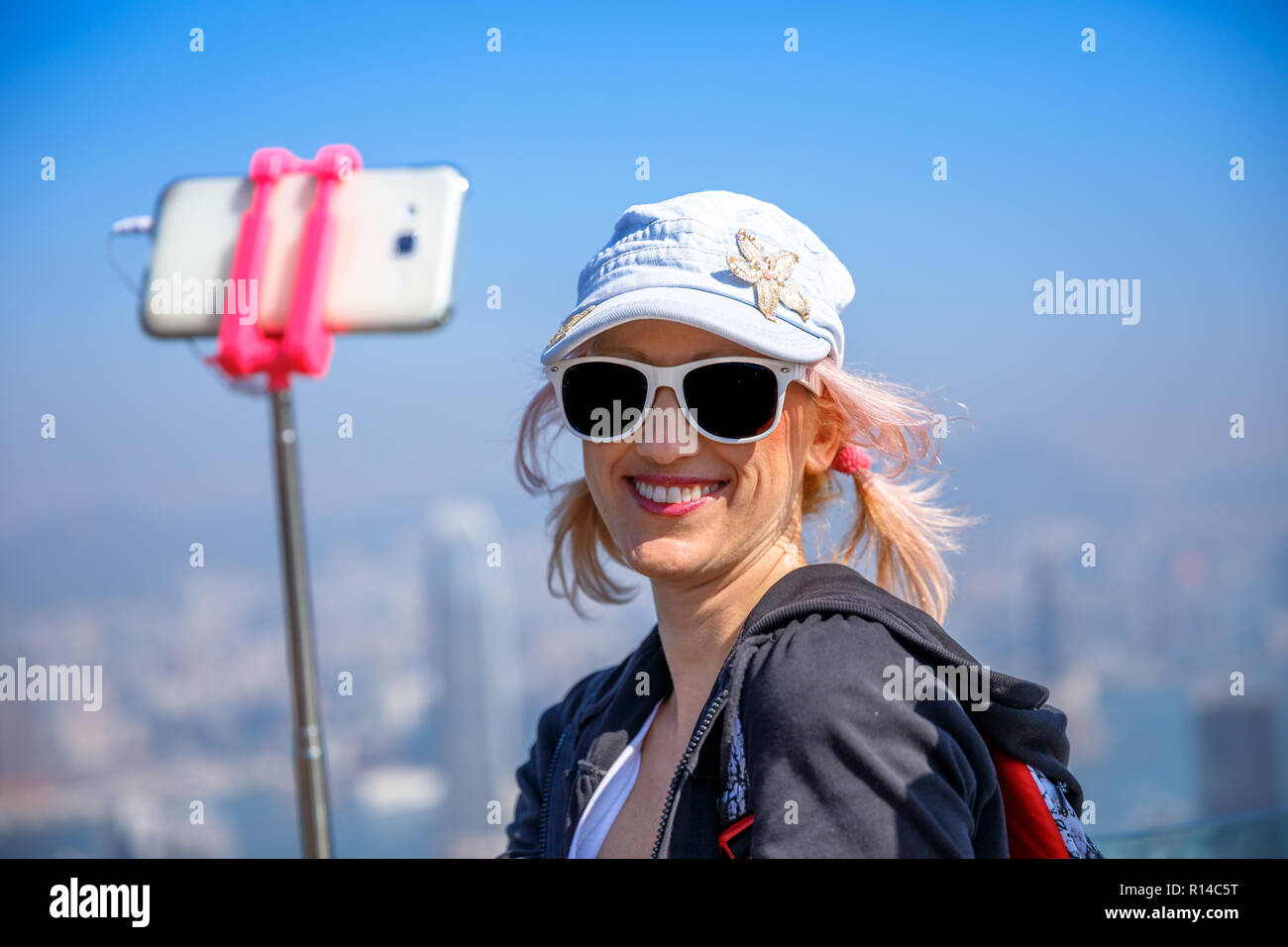Hong Kong Victoria Peak woman taking selfie stick picture photo with ...